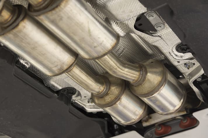 The underside of a modern car, featuring the exhaust system catalytic converters