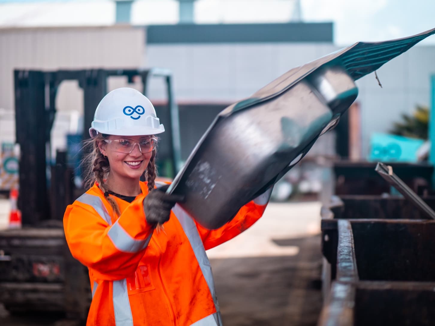 A young woman showing how metal is recycled at Endless