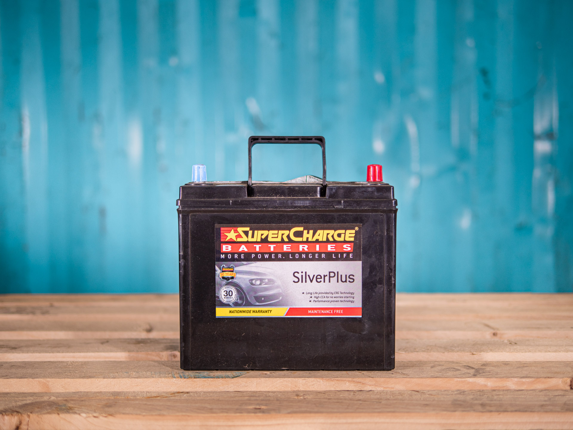Lead acid car battery sitting on a wooden bench for scrap battery disposal and recycling in Auckland.