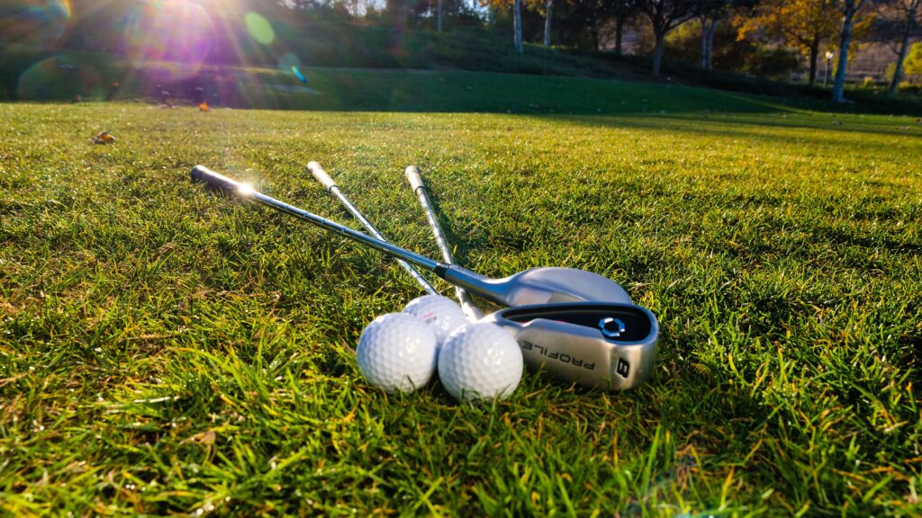Golf clubs and golf balls on grass for golf club recycling in Auckland