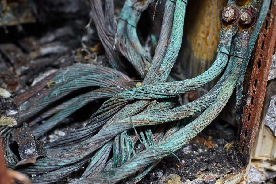 Tarnished copper conductor — dull dark-brown surface oxidation, no other contamination