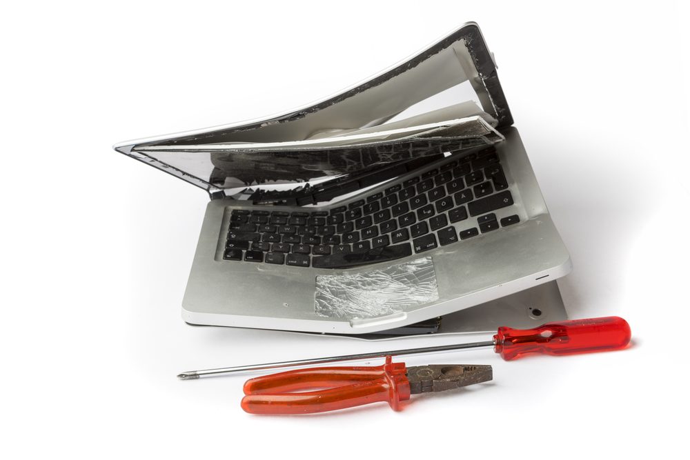 e-waste — laptop with cracked screen and circuit board